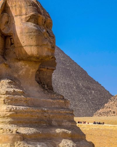 Сфинкса в близък план и частичен изглед към една от пирамидите в Гиза, Египет